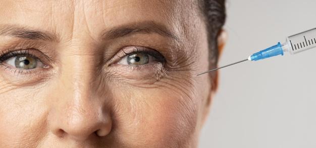 Elder woman using injection for her eye wrinkles Free Photo