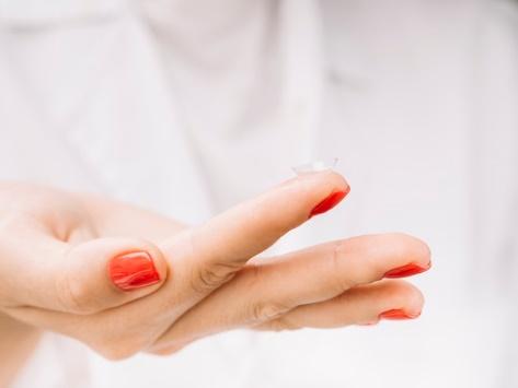 Woman holding contact lenses on her finger Free Photo